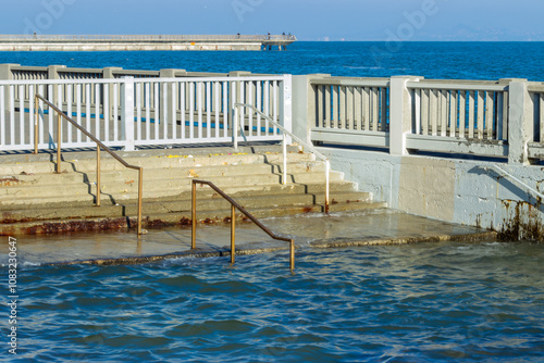 Obraz na płótnie Steps and a railing near the Embarcadero in San Francisco submerged in water during a king tide, this scene highlights the impact of rising sea levels and coastal flooding on urban infrastructure. w salonie