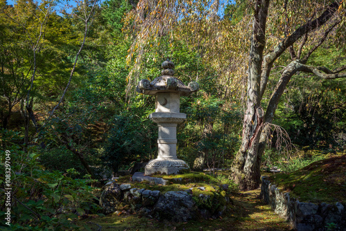 Stone Lantern (ishi-dore) in the Japanese garden of the Tenryu-ji Buddhist Temple on a sunny autumn day, Kyoto, Ukyo Ward, Japan photo