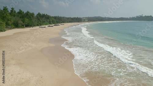 A peaceful aerial view of Talalla Beach in Sri Lanka, showcasing soft sandy shores, calm ocean waves, and lush greenery. Ideal for travel, tropical destinations, and nature-inspired projects. photo