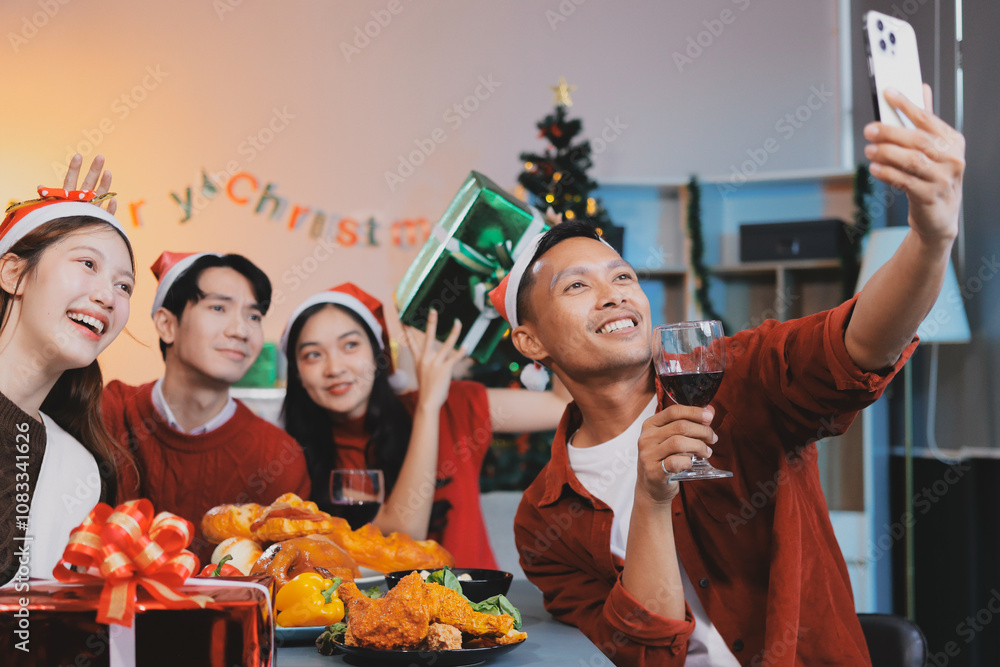 Obraz premium Group of young Asian man and women as friends having fun at a New Year's celebration, holding gift boxes standing by Christmas tree decoration, midnight countdown Party at home with holiday season.