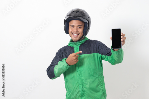 Portrait of Asian online taxi driver wearing green jacket and helmet showing and presenting blank screen mobile phone. Isolated image on white background photo