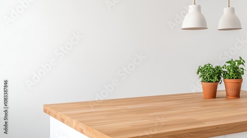 A modern kitchen countertop featuring wooden surface and potted plants under stylish pendant lights, creating a warm and inviting atmosphere.