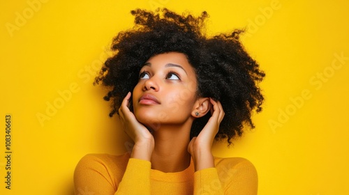 Curious woman overhearing intently on yellow background photo