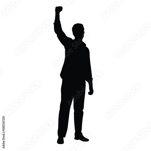 A man is standing in front of a white background. He is wearing a suit and is holding his fist up in the air