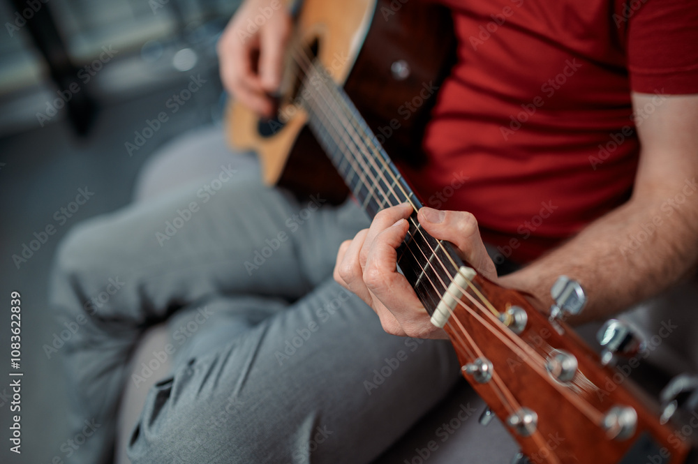 Fototapeta premium Guitarist on acoustic guitar playing melody in studio. Close up musician instrument