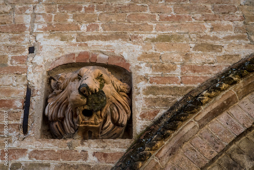 Il muso del leone scolpito sulla facciata di un palazzo storico di Portogruaro, in Veneto, come ornamento photo