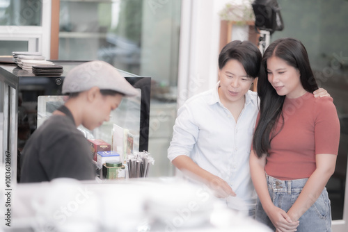 Couple Selecting Beverages at a Modern Cafe Counter with Barista Assistance in a Cozy Atmosphere