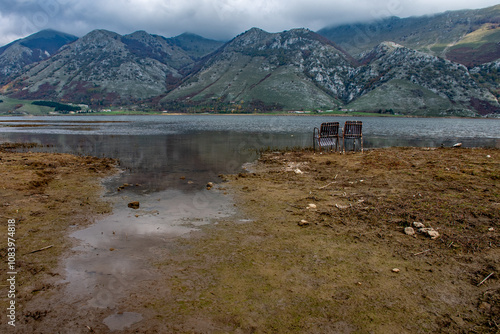 Two old chairs on the shore of the lake photo