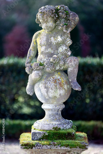 Stone scupture in a park. Child with roses.  France. photo