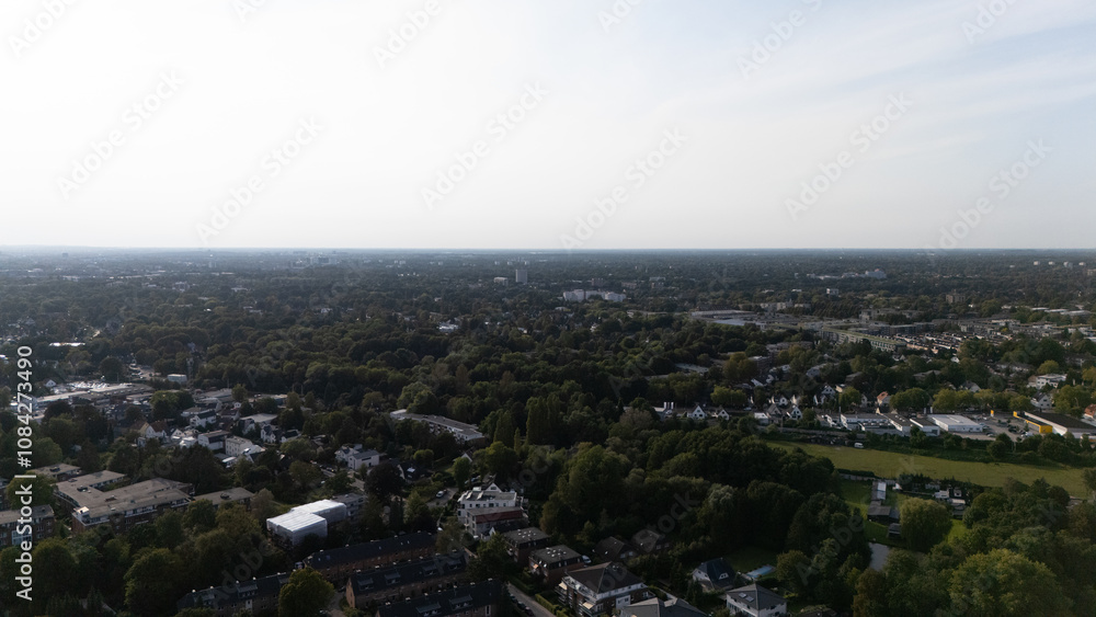 Fototapeta premium Expansive Aerial View of Suburban Neighborhood and Lush Forest