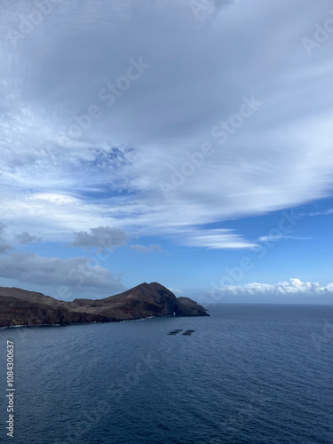Serene Coastal Landscape with Rocky Island and Blue Skies
