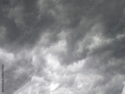 Atmospheric dark gray storm with dramatic clouds in the sky creating a gloomy and anxious mood before the thunderstorm photo