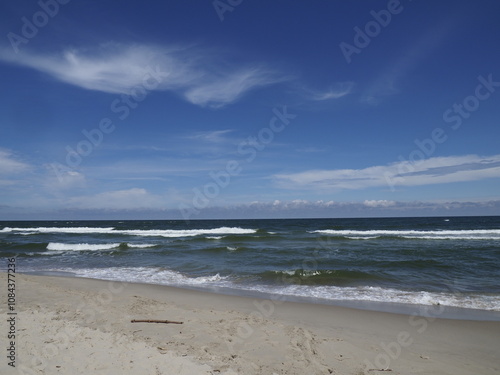 Beach with waves and blue sky on a clear day at the coast