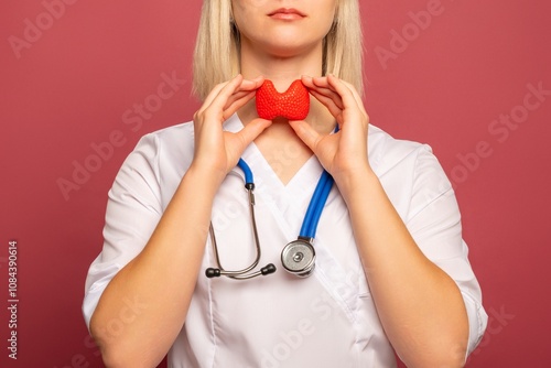 Female doctor is holding anatomical model thyroid gland. Help and care concept photo