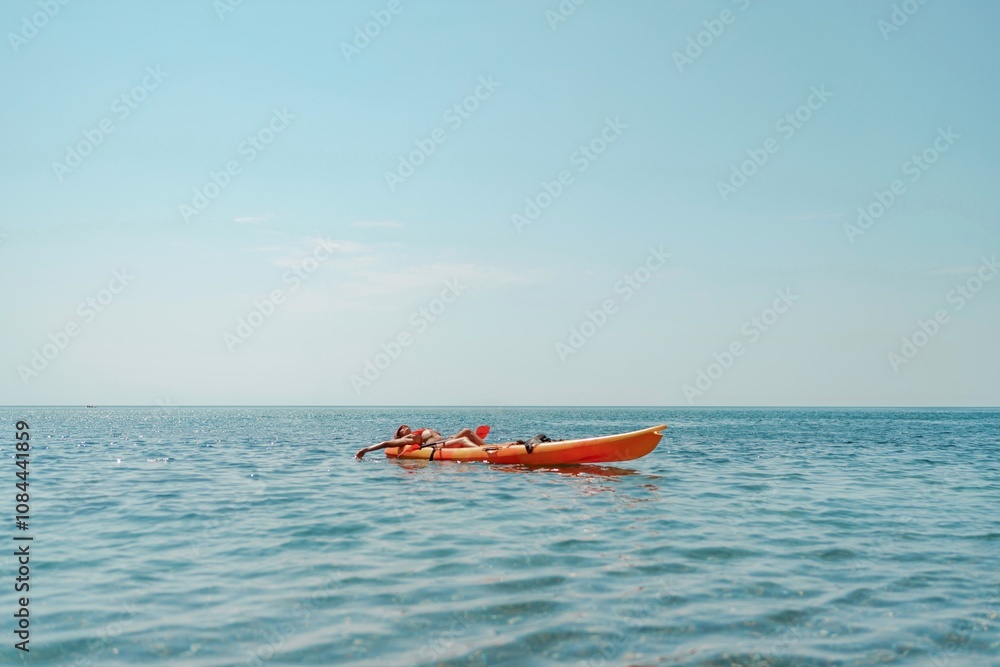 Obraz premium Kayak sea woman. Happy attractive woman with long hair in red swimsuit, swimming on kayak. Summer holiday vacation and travel concept.