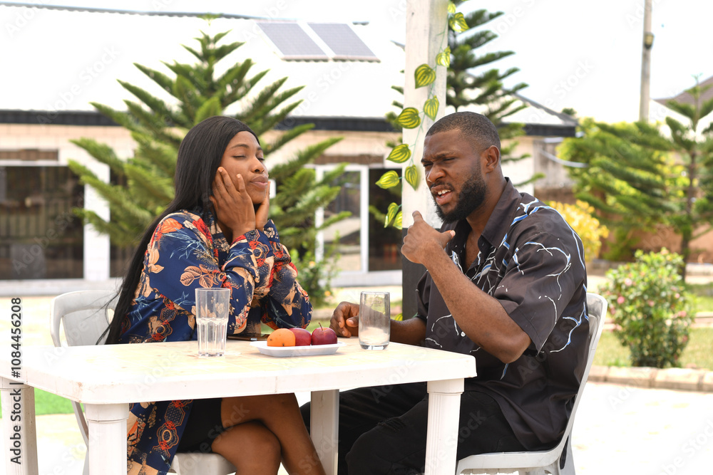 A man and a woman are sitting at a table with a glass of water and a glass of orange juice. having a good time together A man and a woman are sitting at a table with a glass of water and a glass of orange juice. having a good time together