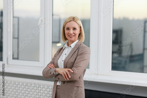 Portrait of smiling middle aged woman with crossed arms in office