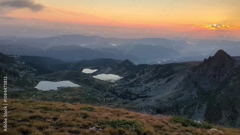 The Seven Rila Lakes in Bulgaria at dawn present a breathtaking view from the mountaintop, as early morning light reflects off the clear waters of the lakes surrounded by the rugged alpine terrain. The Seven Rila Lakes in Bulgaria at dawn present a breathtaking view from the mountaintop, as early morning light reflects off the clear waters of the lakes surrounded by the rugged alpine terrain.