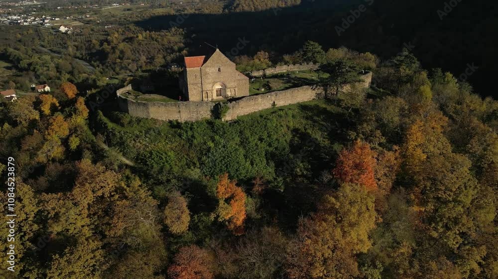 Aerial view of ancient stone church surrounded by autumn forest. Picturesque landscape with vibrant fall foliage and distant mountains. Ideal for travel, history, or nature projects. Aerial view of ancient stone church surrounded by autumn forest. Picturesque landscape with vibrant fall foliage and distant mountains. Ideal for travel, history, or nature projects.