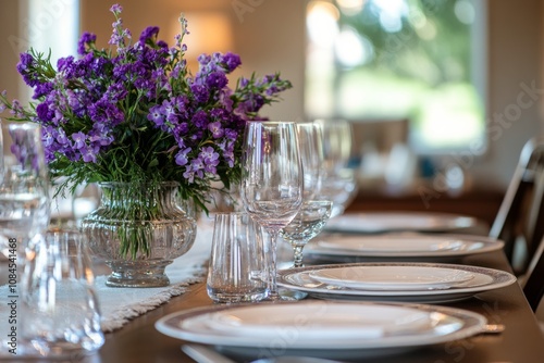 Elegant dining setup with floral centerpiece featuring purple flowers in a so...