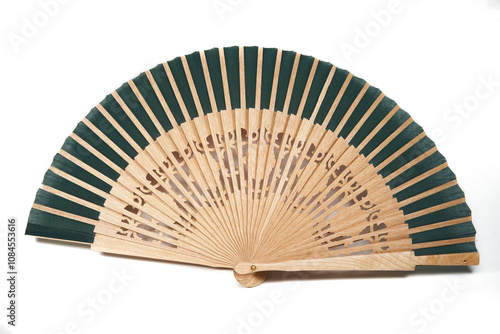 Isolated spanish style timber and cloth green fan for hot summer days over white background