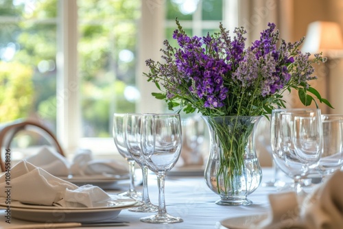 Elegant dining setup with floral centerpiece featuring purple flowers in a so...