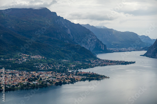 Aerial view of picturesque Lake Como with surrounding mountains and lakeside towns, showcasing natural beauty and tranquility at sunset.