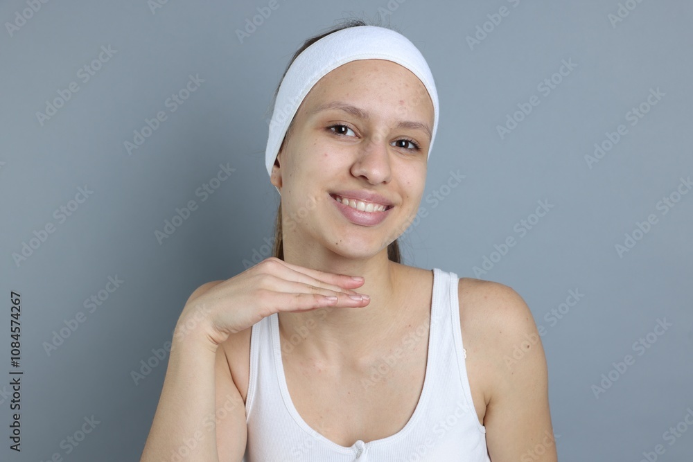 Teenage girl with acne problem on grey background Teenage girl with acne problem on grey background