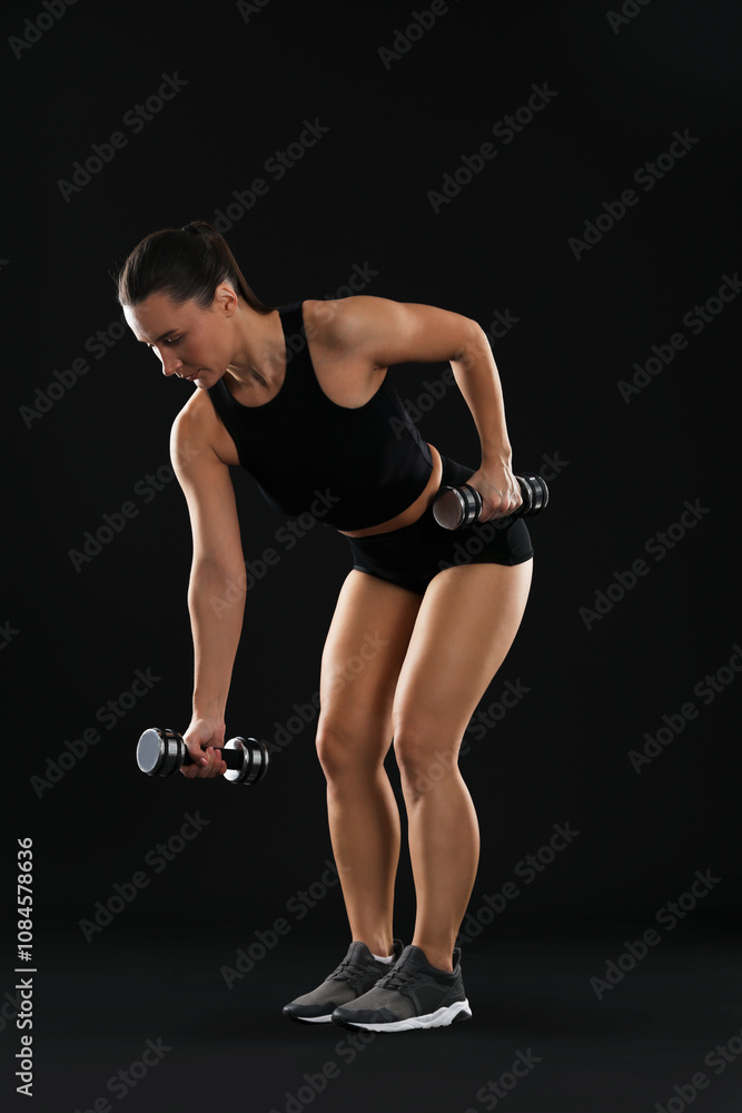 Woman exercising with dumbbells on black background Woman exercising with dumbbells on black background