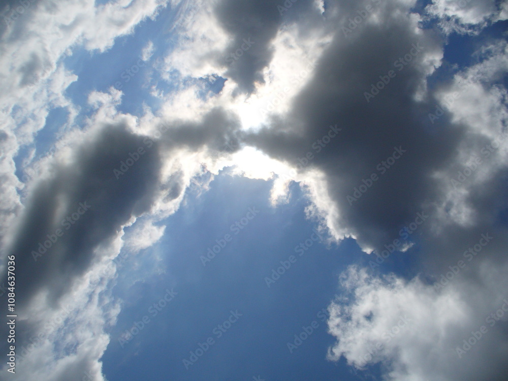 Sunny blue sky with sunlight and Stratocumulus clouds - natural background. Topics: pattern, weather, meteorology, sun energy, season, beauty of nature, air space Sunny blue sky with sunlight and Stratocumulus clouds - natural background. Topics: pattern, weather, meteorology, sun energy, season, beauty of nature, air space