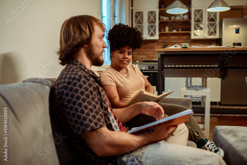 Two friends studying together with books in a cozy kitchen setting