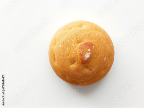 Freshly baked round bread on a white surface with a light golden crust showcasing a simple and inviting appearance