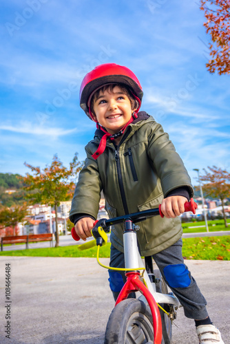 A young boy is riding a bike with a red helmet on