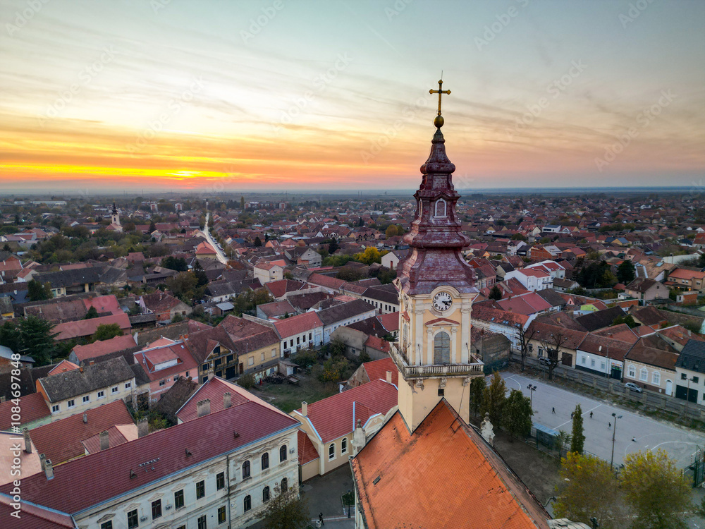 Fototapeta premium European bell tower with old red roof town in the background, Vršac, Serbia - aerial drone photo