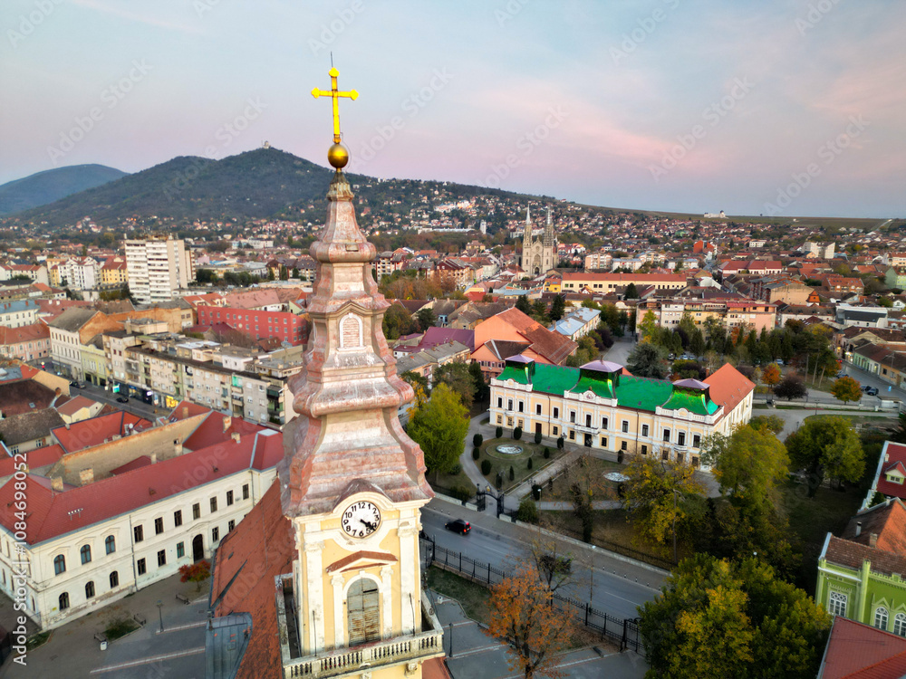Fototapeta premium European bell tower with old red roof town in the background, Vršac, Serbia - aerial drone photo