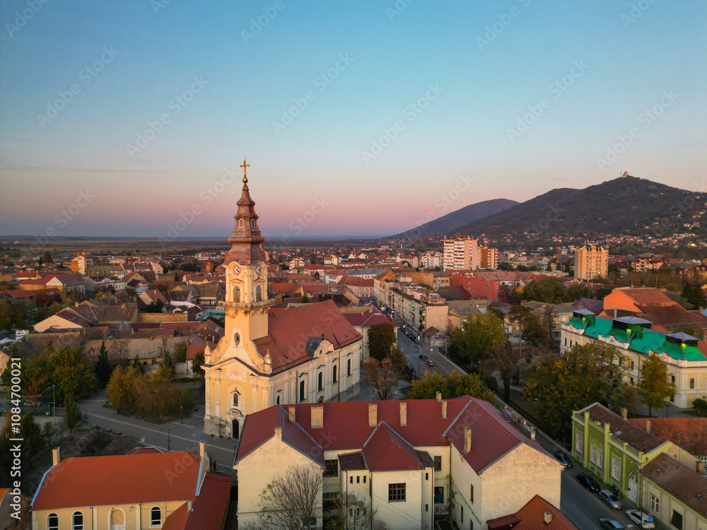 Obraz premium European bell tower with old red roof town in the background, Vršac, Serbia - aerial drone photo