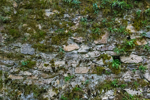 Details of old stone wall with moss with strong texture