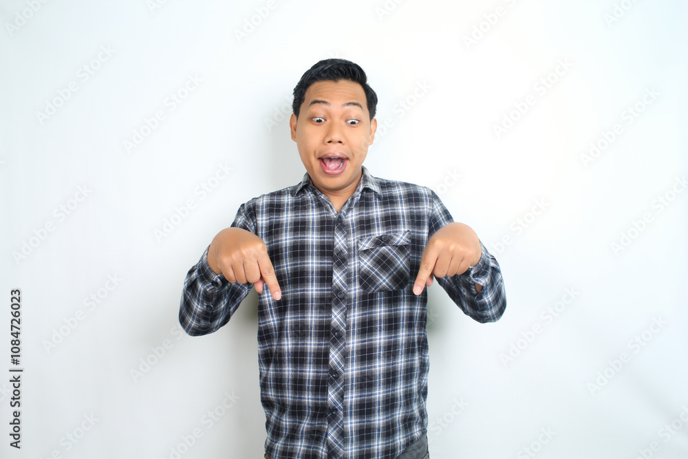 Fototapeta premium surprised and shock asian man pointing hand to copy space wearing casual plaid shirt isolated on white