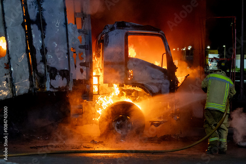 Firefighters spray water on fire in large cargo truck	
