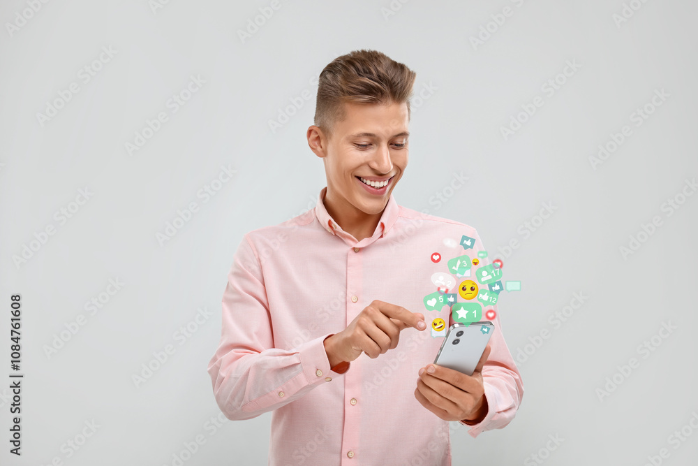 Happy man using mobile phone on white background. New message sign and other notifications over gadget Happy man using mobile phone on white background. New message sign and other notifications over gadget