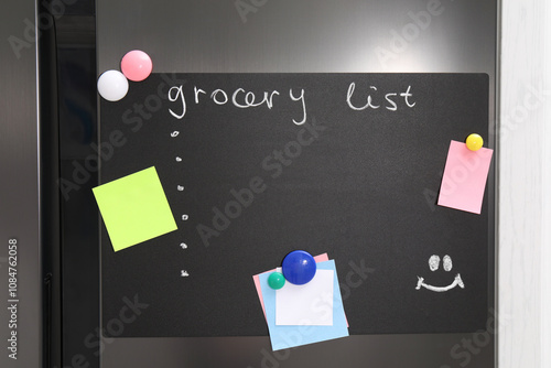 Magnetic board with grocery list and notes on refrigerator in kitchen photo