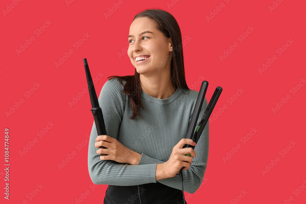 Female hairdresser with curling iron and flattening iron on red background Female hairdresser with curling iron and flattening iron on red background