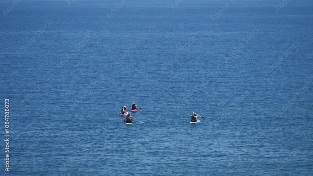 Catch a beautiful glimpse of two surfers skillfully riding the waves in the serene and vibrant blue ocean Catch a beautiful glimpse of two surfers skillfully riding the waves in the serene and vibrant blue ocean