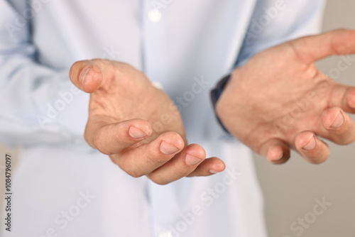 Man holding something on grey background, closeup