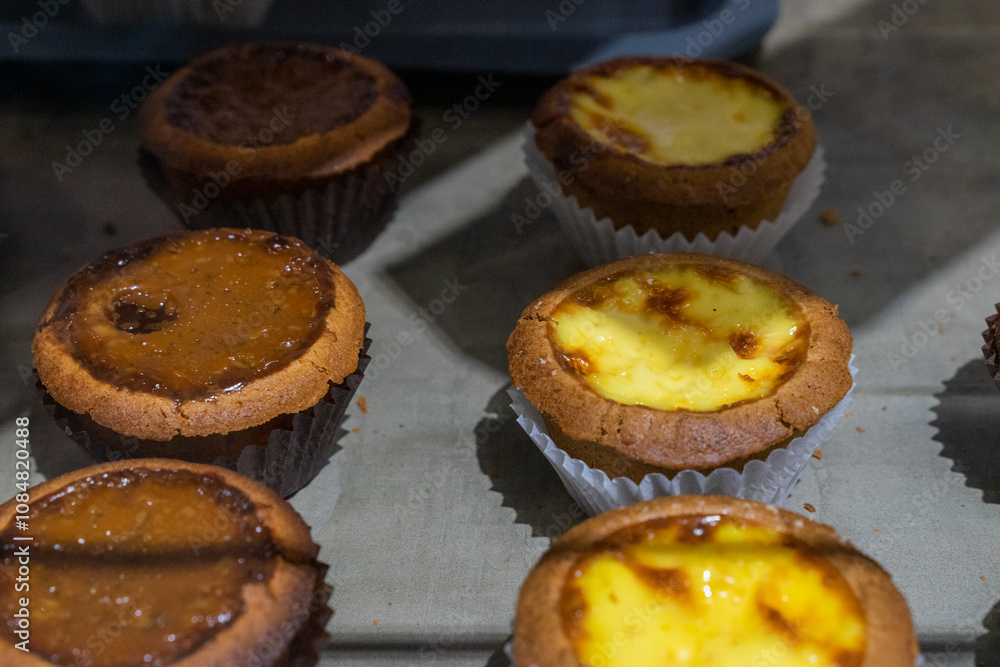 the irresistible allure of freshly baked egg tarts, their golden, flaky crusts perfectly crisp and their creamy custard filling gleaming under the light. the irresistible allure of freshly baked egg tarts, their golden, flaky crusts perfectly crisp and their creamy custard filling gleaming under the light.