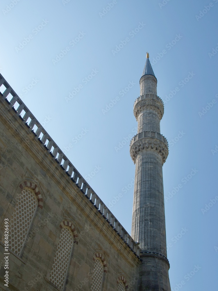 Minaret of Sultan Ahmet Mosque standing against the blue sky in Istanbul, Turkey