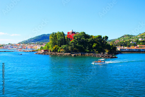 Interesting view from Ischia at the Zoological Station Anton Dohrn - Distaccamento Villa Dohrn, a red building surrounded by trees, the Tyrrhenian Sea, a lone tourist boat and San Pietro beach photo