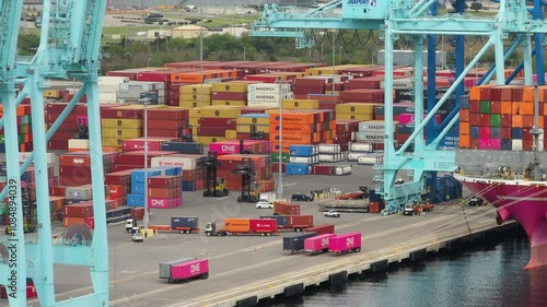 Freight containers for international shipment of produced goods. Unloading container ship in port of Savannah, Georgia.