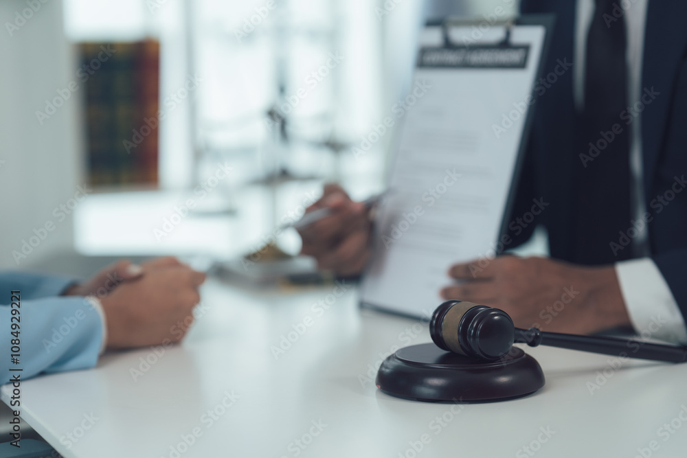 Legal Counsel: A judge's gavel rests on a table, symbolizing justice and authority in a formal courtroom setting. Close-up view of a lawyer and client signing legal documents. Legal Counsel: A judge's gavel rests on a table, symbolizing justice and authority in a formal courtroom setting. Close-up view of a lawyer and client signing legal documents.