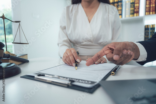 Legal Consultation:  A lawyer guides a client through important documents, signifying trust and expertise in a professional setting. photo